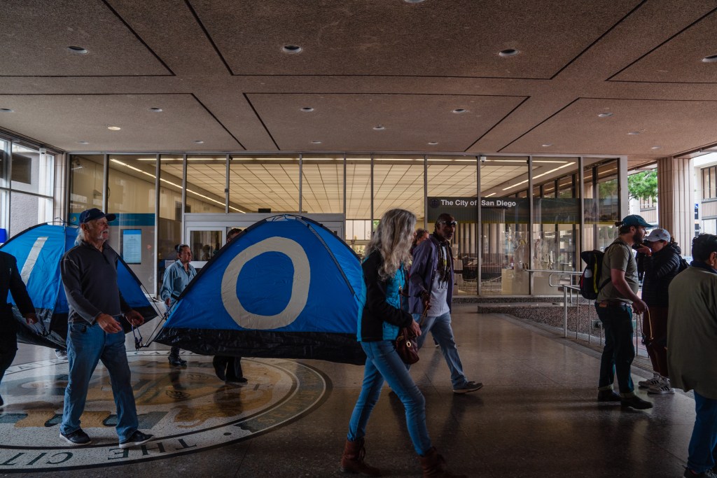 People who are homeless and protesters gather march in downtown on May 23, 2023, against the proposed encampment ban.
