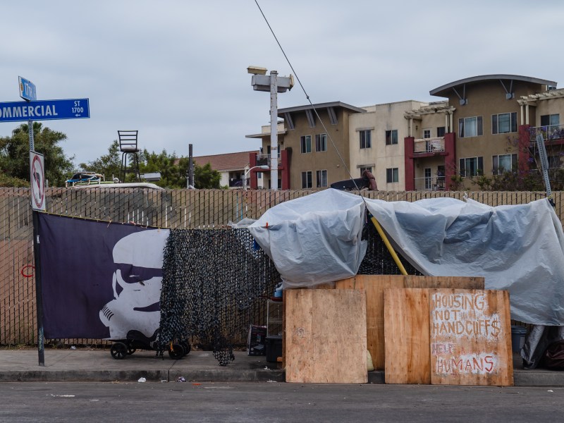A sign that reads "Housing Not Handcuffs, Help Humans" propped in front of an encampment on the corner of Commercial and 17th Street in the East Village on May 23, 2023.