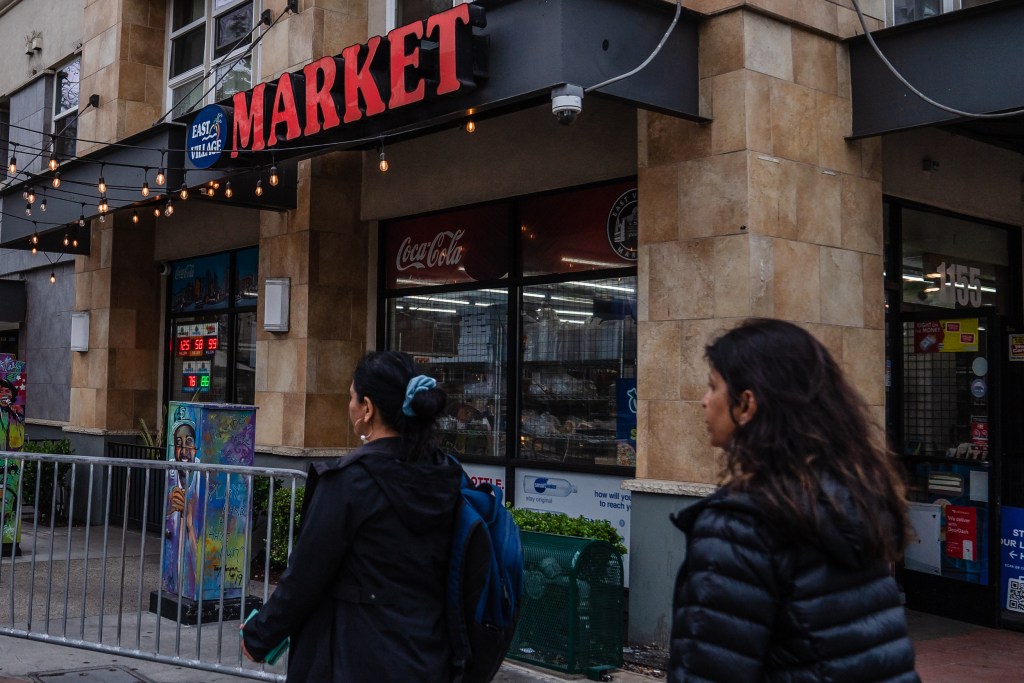 Women walk passed the East Village Market on May 12, 2023.