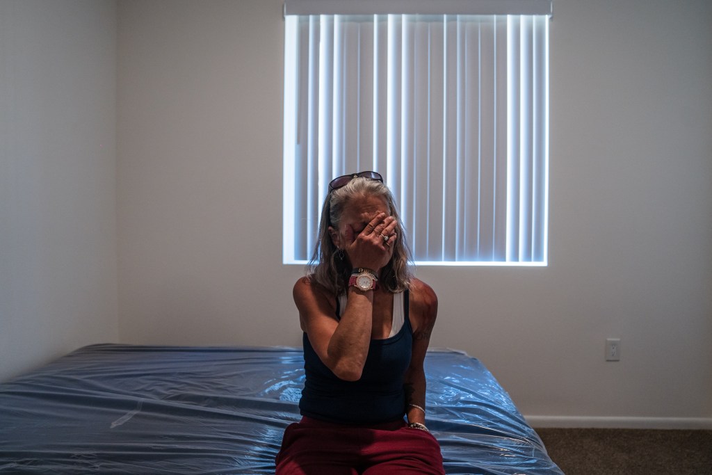Rachel Hayes sits in her new apartment and is overcome with emotion in San Ysidro on June 20, 2023. Hayes has not lived in a home since 2012.