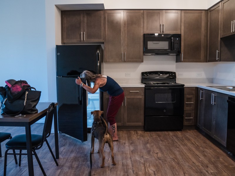 Rachel Hayes with her dog Nino in her new apartment in San Ysidro on June 20, 2023.