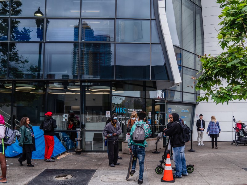 People that are unhoused stand outside of the Homelessness Response Center in the East Village waiting to see if they will be able to stay in shelter on June 5, 2023.