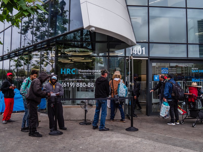 People that are unhoused stand outside of the Homelessness Response Center in the East Village waiting to see if they will be able to stay in shelter on June 5, 2023.