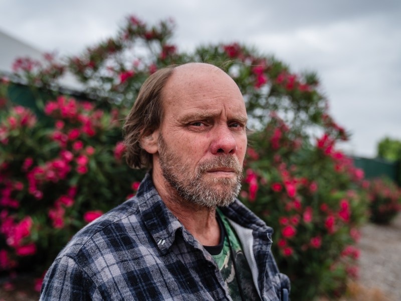 Raymond Hill stands near an Alpha Project shelter in the Midway District on June 5, 2023.
