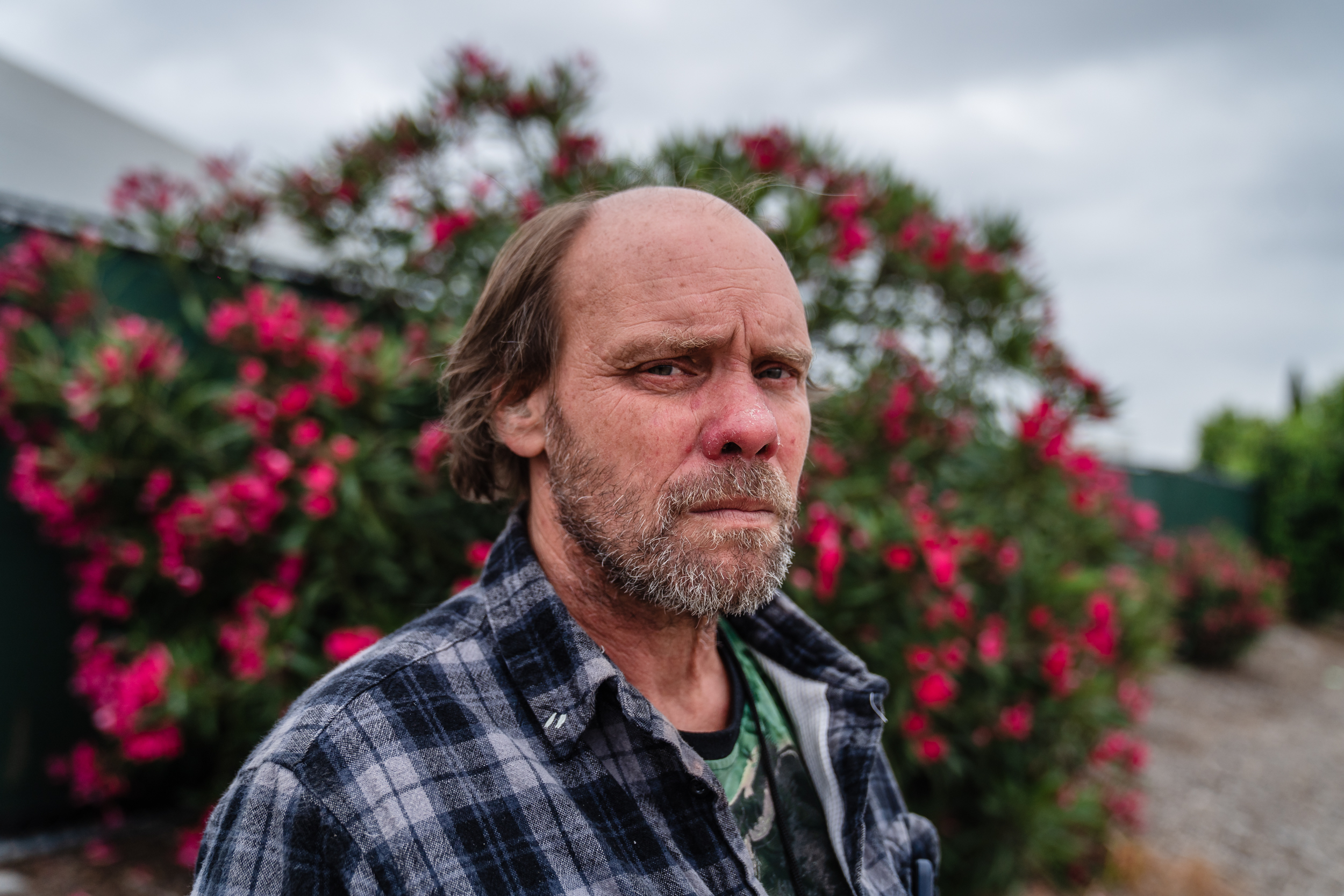 Raymond Hill stands near an Alpha Project shelter in the Midway District on June 5, 2023.