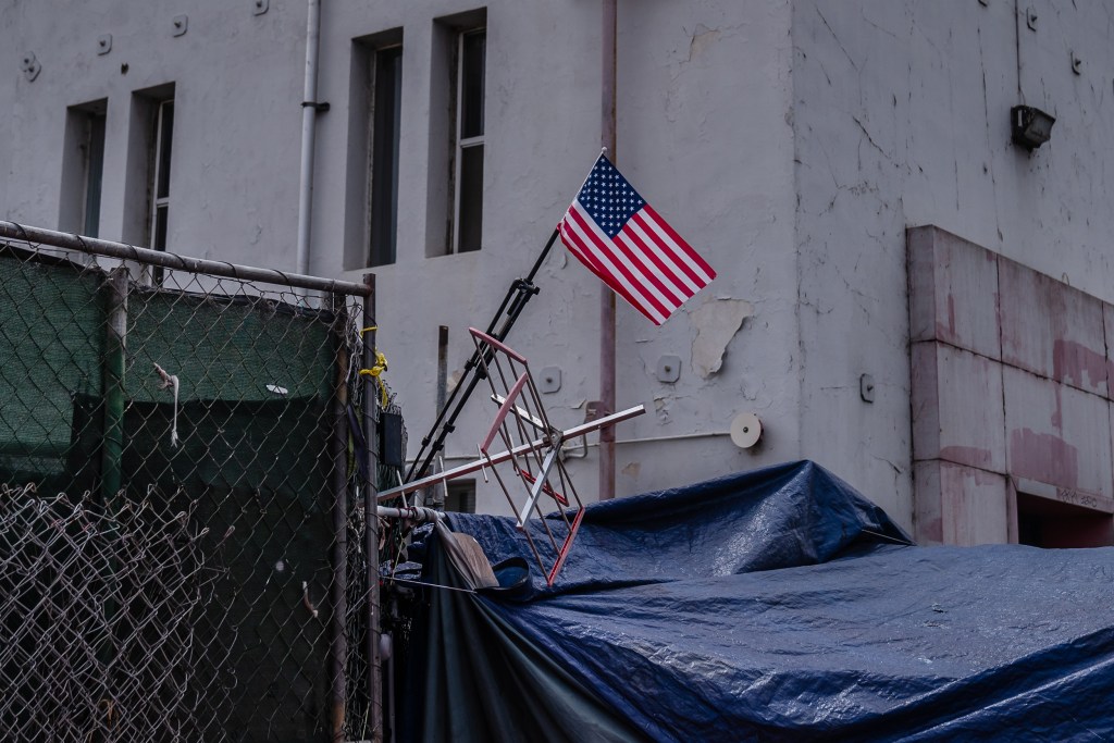 An American flag hangs above a tent in a homeless encampment on National Avenue in the East Village on June 9, 2023.