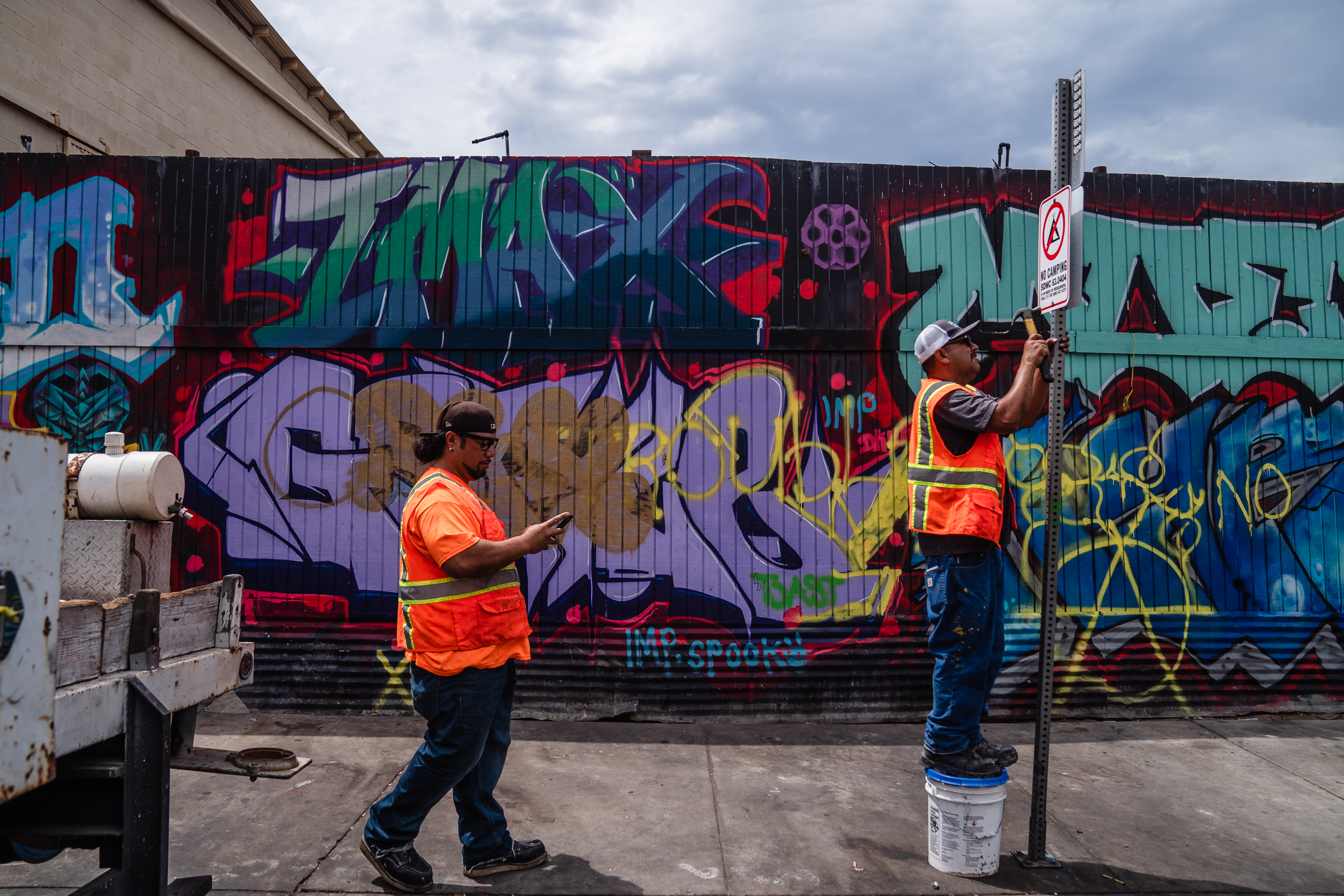 A city of San Diego worker puts a "No Camping" sign on Commercial Street in the outskirts of downtown on July 31, 2023.
