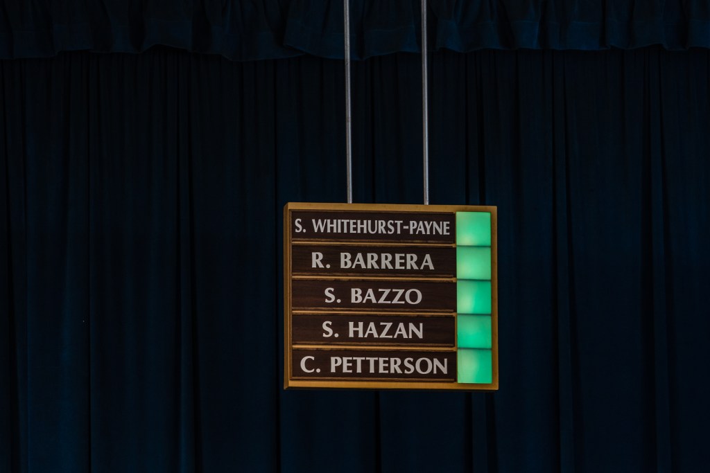 Green lights can be seen during voting next to members names of the San Diego Unified District during a meeting in University Heights on July 11, 2023.