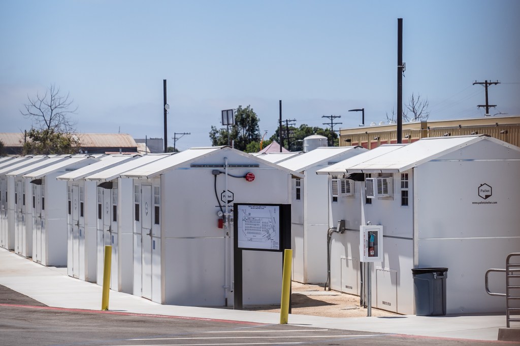 View through the fence of the Chula Vista Village at Otay, a 65 white, prefab shelter units for the homeless on July 18, 2023.