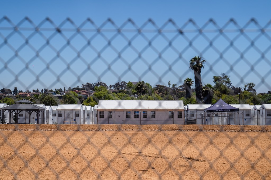 View through the fence of the Chula Vista Village at Otay, a 65 white, prefab shelter units for the homeless on July 18, 2023.