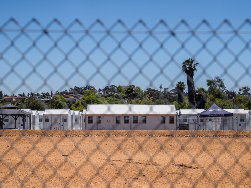 View through the fence of the Chula Vista Village at Otay, a 65 white, prefab shelter units for the homeless on July 18, 2023.