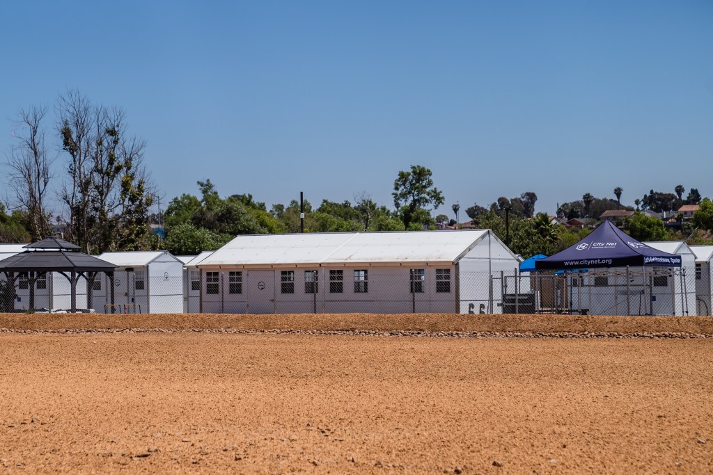 View through the fence of the Chula Vista Village at Otay, a 65 white, prefab shelter units for the homeless on July 18, 2023.
