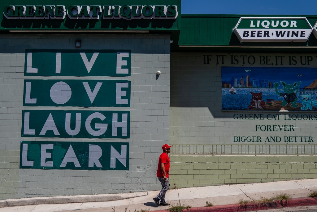 A man walks past Green Cat Liquors in Lincoln Park on Tuesday, Aug. 15, 2023. / Photo by Ariana Drehsler