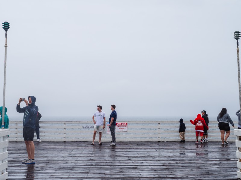 People on Crystal Pier in Pacific Beach before tropical storm Hilary makes landfall on Aug. 20, 2023.