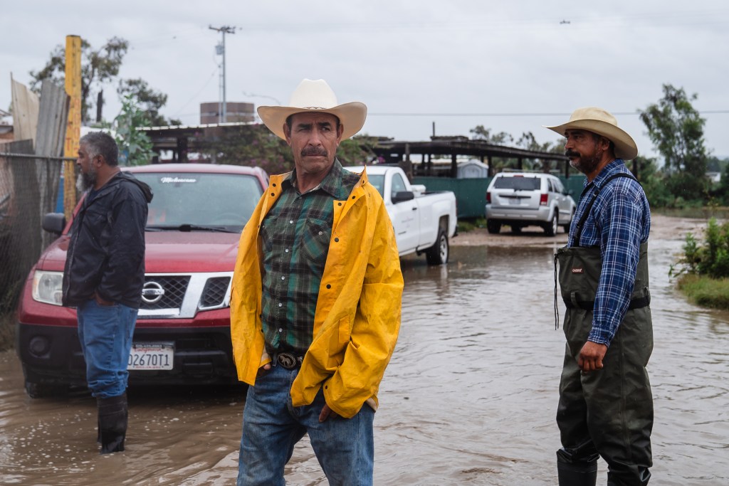 Danny Moreno (right) and other ranchers look at the water level in San Ysidro on Aug. 20, 2023.