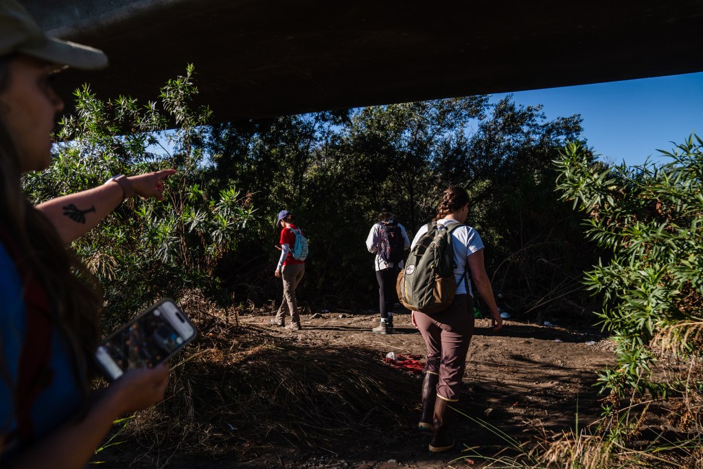 The San Diego River Park Foundation's Chief Operating Officer Sarah Hutmacher (second to right), Program Manager Rachel Downing (far left), and interns Lena Munoz (center), and Miranda Stormer during a survey in Mission Valley's riverbed on Aug. 22, 2023.