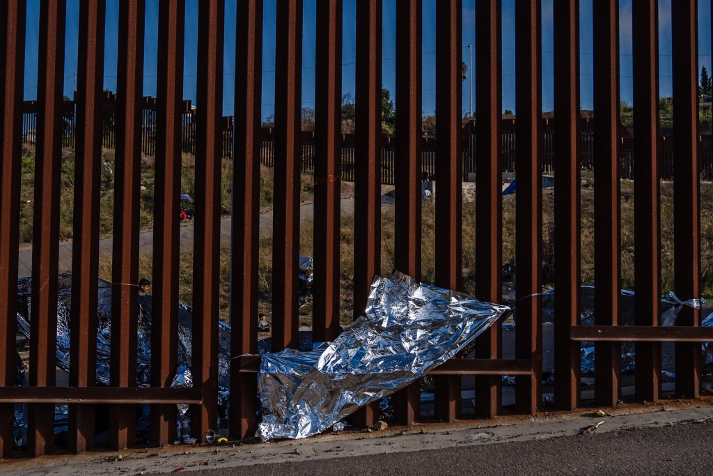 A Mylar blanket can be seen against the border wall in San Ysidro on Sept. 12, 2023.