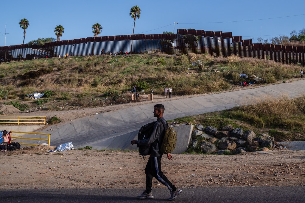 Asylum seekers in between the primary and secondary border walls while they wait to be processed by U.S Immigration in San Ysidro on Sept. 12, 2023.