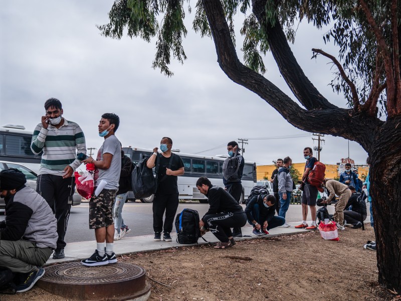 Asylum seekers dropped at off near the Iris Avenue Trolley Station in Otay Mesa on Sept. 14, 2023. After being dropped off, some were trying to figure out how they could reach out to friends and family to meet them or be picked up.