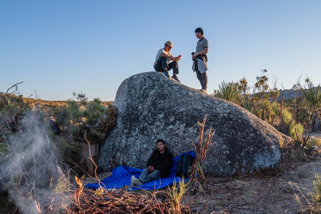 Men from China at a makeshift camp near Jacumba on Sept. 17, 2023 wait for U.S. customs and border patrol to take them to be processed. Migrants from Russia, Turkey, Ecuador, Brazil, India, Colombia and Guatemala have also been staying at the camp.