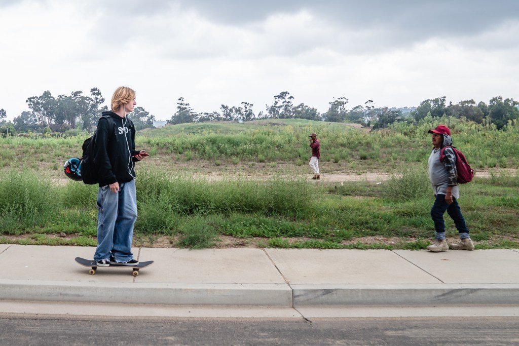 Antonio Jacobo (right) and another farmer walk towards a bus stop after working on a farm in Carlsbad on Sept. 21, 2023.