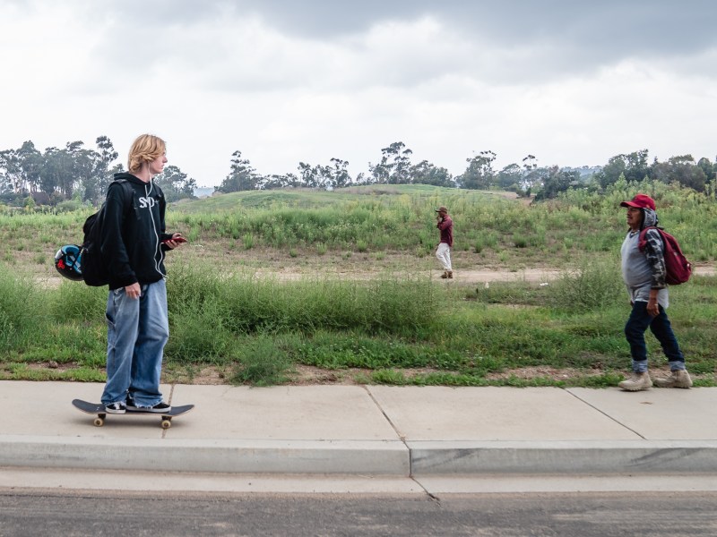Antonio Jacobo (right) and another farmer walk towards a bus stop after working on a farm in Carlsbad on Sept. 21, 2023.
