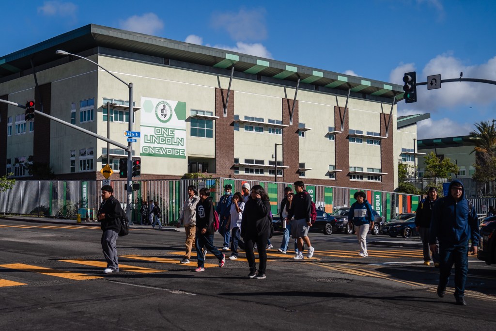 Students cross the street in front of Lincoln High School on Oct. 23 2023.