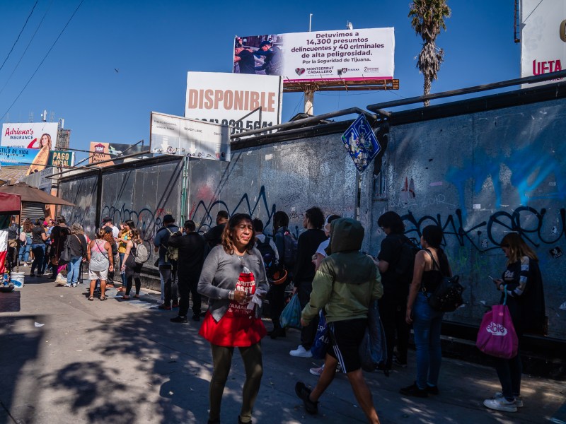 People wait in a long line border crossing to enter the United States from Tijuana on Oct. 6, 2023.