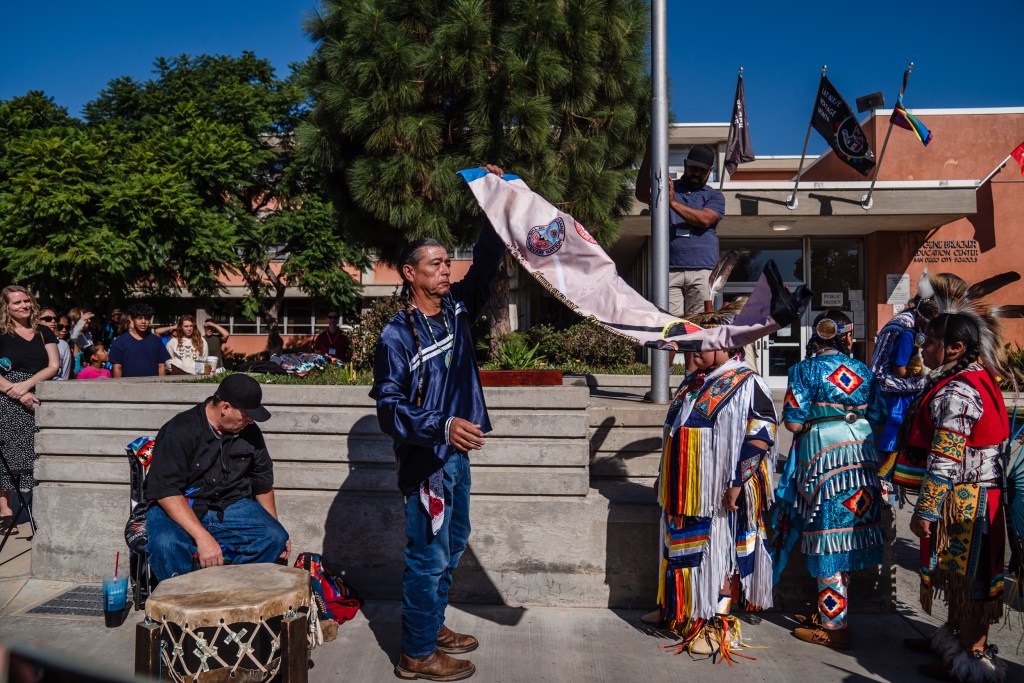 Bobby Wallace of the Barona Band of Mission Indians holds the Kumeyaay flag at San Diego Unified in University Heights on Nov. 3, 2023.