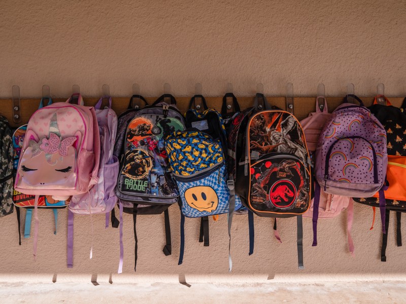 Backpacks hang on the wall outside a classroom at Madison Elementary School in El Cajon on Nov. 9, 2023.