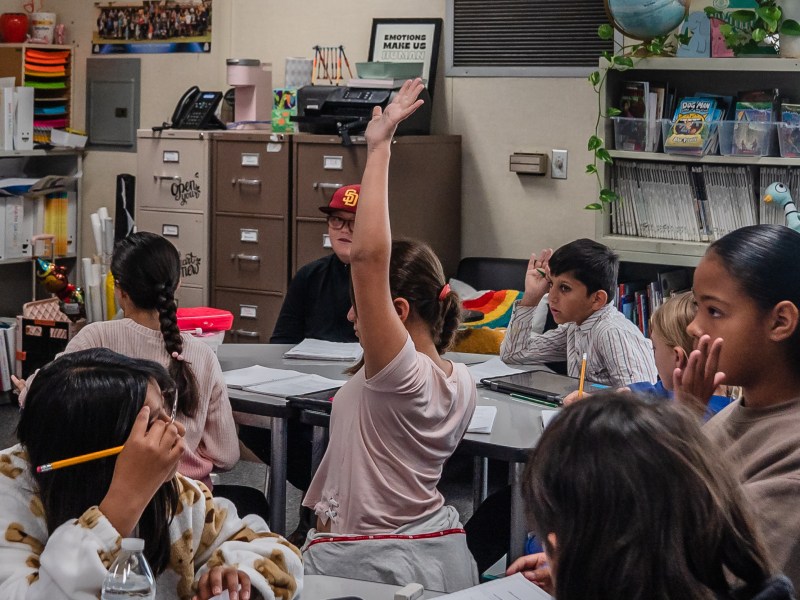Fifth graders raise their hands while working on a class assignment at Madison Elementary School in El Cajon on Nov. 9, 2023.