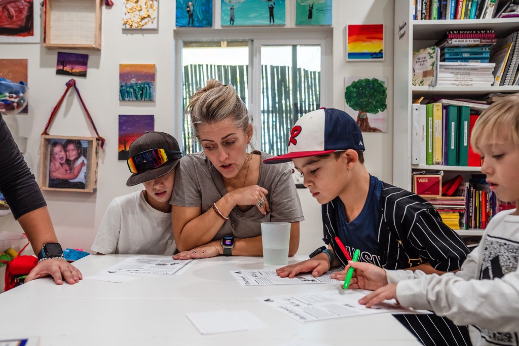 Sara Shields with her son Graeson, 12, Owen Shields, 7 and Jax Loy, 9 during a Virtues and Detachment lesson that Suzette Loy (noti pictured) is teaching in Vista on Dec. 5, 2023.