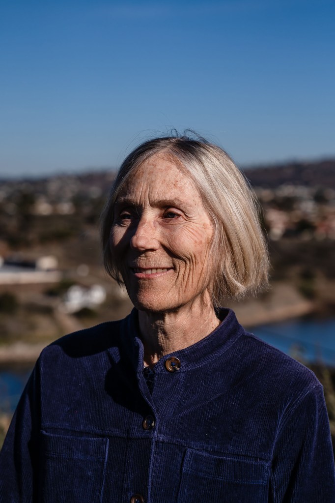 Karen Henry stands near the Sweetwater Reservoir on Jan. 13, 2024. / Ariana Drehsler for Voice of San Diego