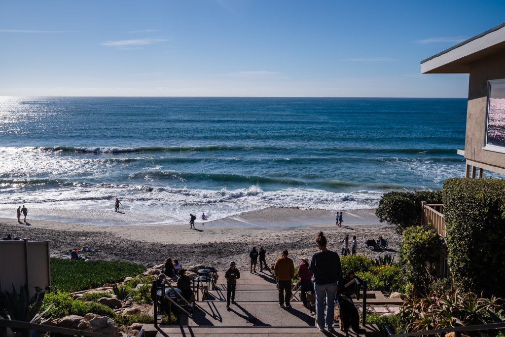 People walk towards the beach in Carlsbad on Jan. 2, 2024.