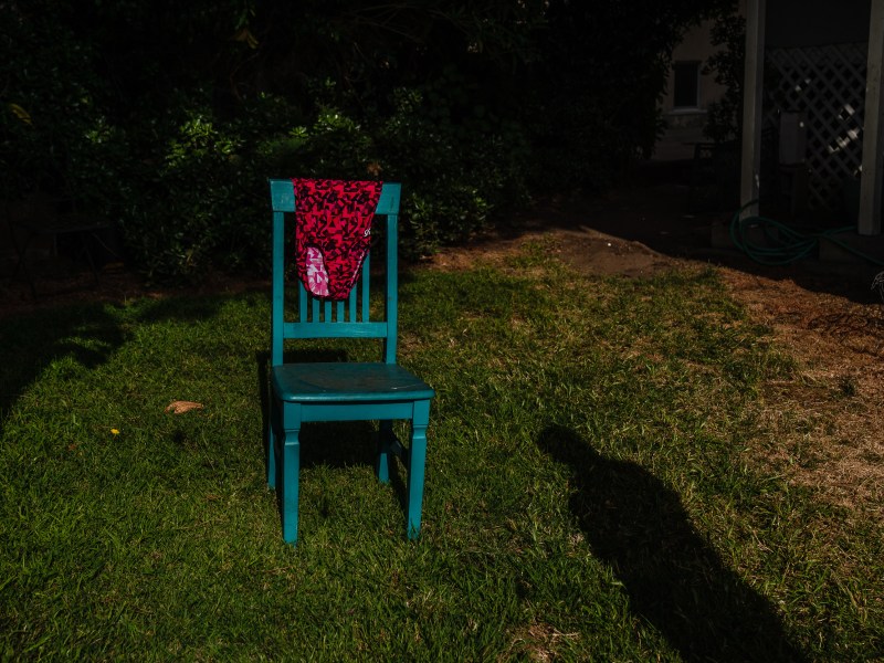 A woman’s shadow can be seen on the ground while a leotard hangs on the chair on May 17, 2024, in San Diego. / Photo by Ariana Drehsler