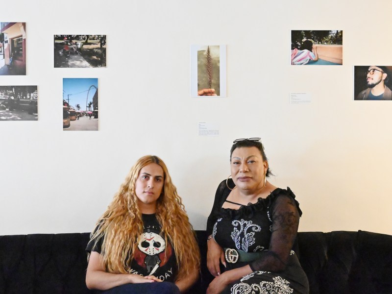 Al Otro Lado’s LGBTQ+ programs coordinator, Brigitte Baltazar Lujano (left), and Susana Barrales, the director of La Casita de Unión Trans which houses Trans asylum seekers in Tijuana, Mexico pose for a portrait at photographic exhibition made by trans women to empower each other at Avenida Revolucion’s Teorema Brewing on Friday, Aug. 9, 2024. Photo by Carlos A. Moreno for Voice of San Diego