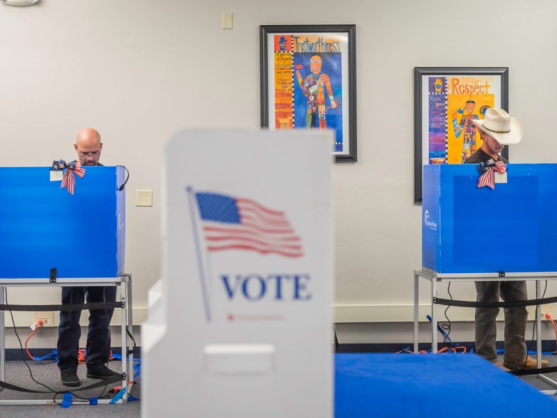 Voters behind voting booths fill out their ballots on Tuesday, Nov. 5, 2024, at Cajon Park School in Santee. / Photo by Vito di Stefano for Voice of San Diego